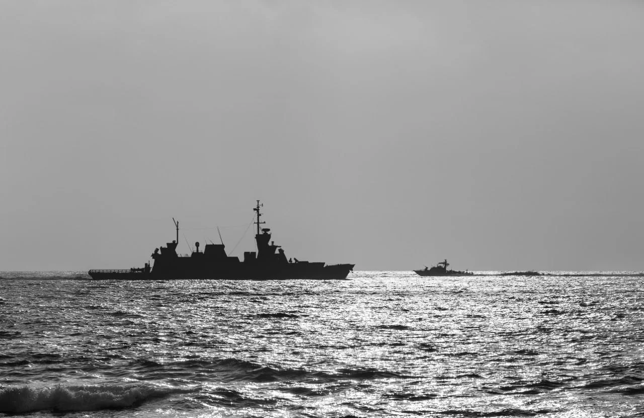 silhouette of a warship at sunset black and white